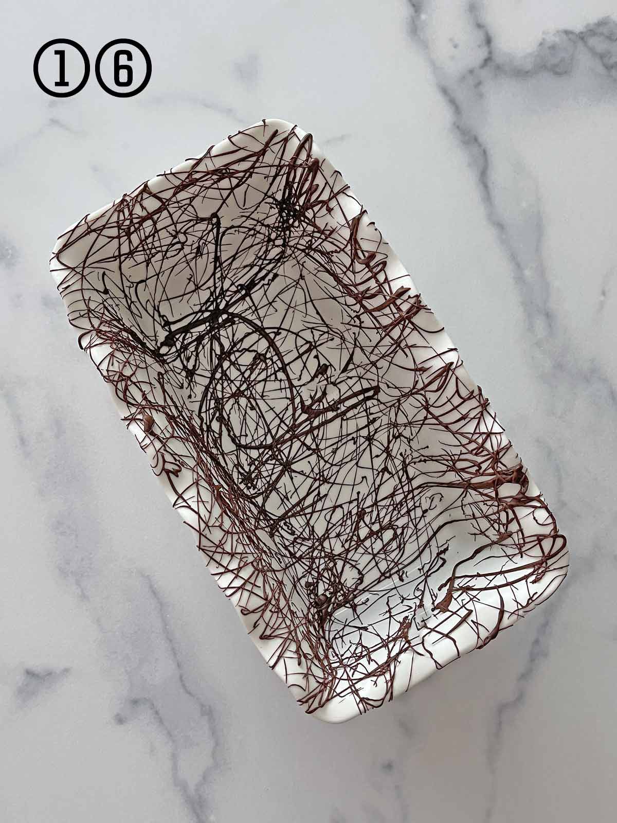 a loaf pan with melted chocolate scribbled on.