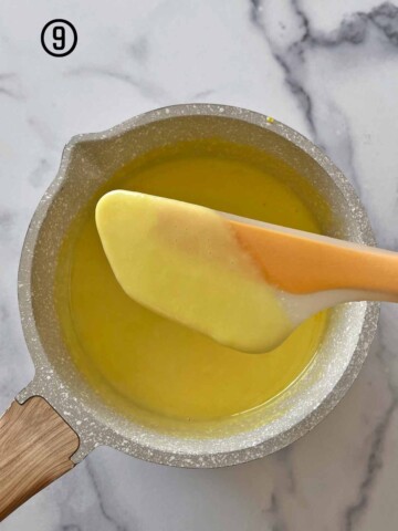 A custard base being stirred in a pan with a silicone spatula.