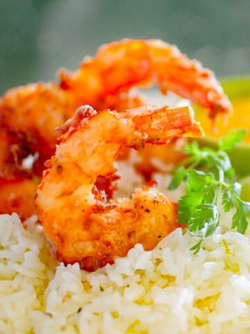 White rice with golden brown coconut shrimp and parsley.