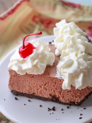 Rick chocolate cream pie with whipped cream and cherry on top.