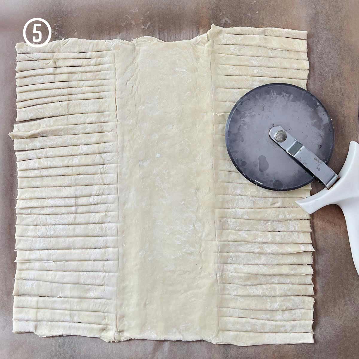 An Easy Apple Pastry Recipe (Strudel) with a pastry cutter cutting dough.