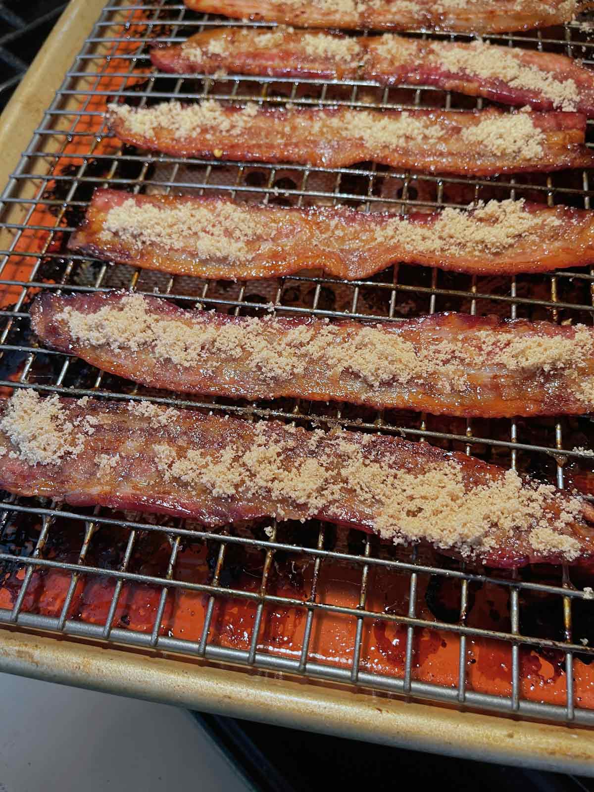 Brown sugar has been applied to the opposite side of the bacon slices.