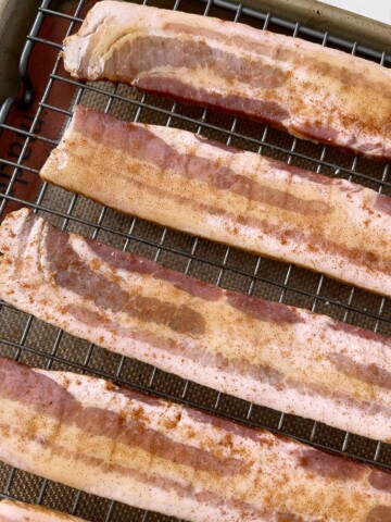 Slices of bacon with cayenne peeps sprinkled on the honey.