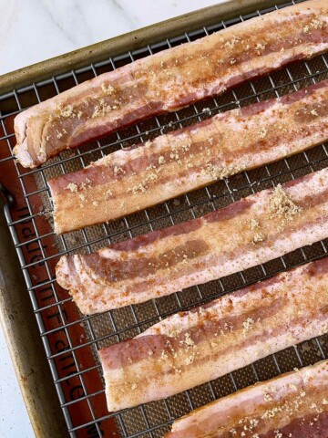 Slices of bacon with brown sugar on top.