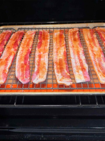 Pan of bacon with toppings going into a 350 degree oven.
