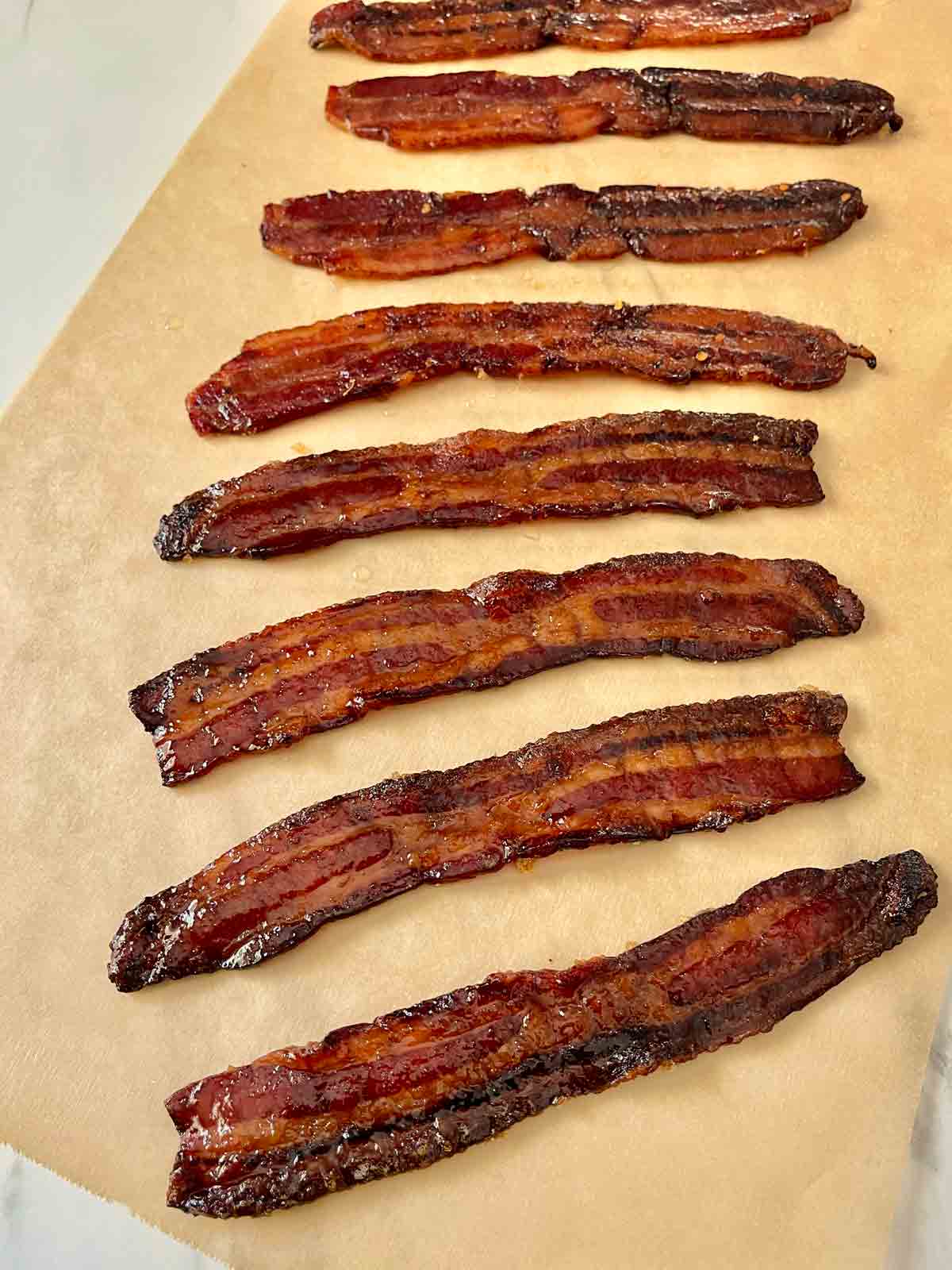 Bacon has been removed from the wire rack and placed onto parchment paper to cool completely.