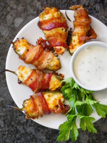 Bacon-wrapped jalapeno popper with a creamy dip.