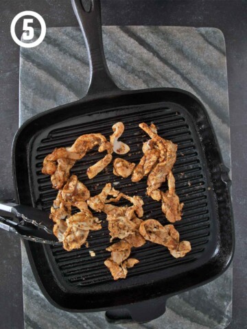 Marinated chicken cooking on a gril pan.