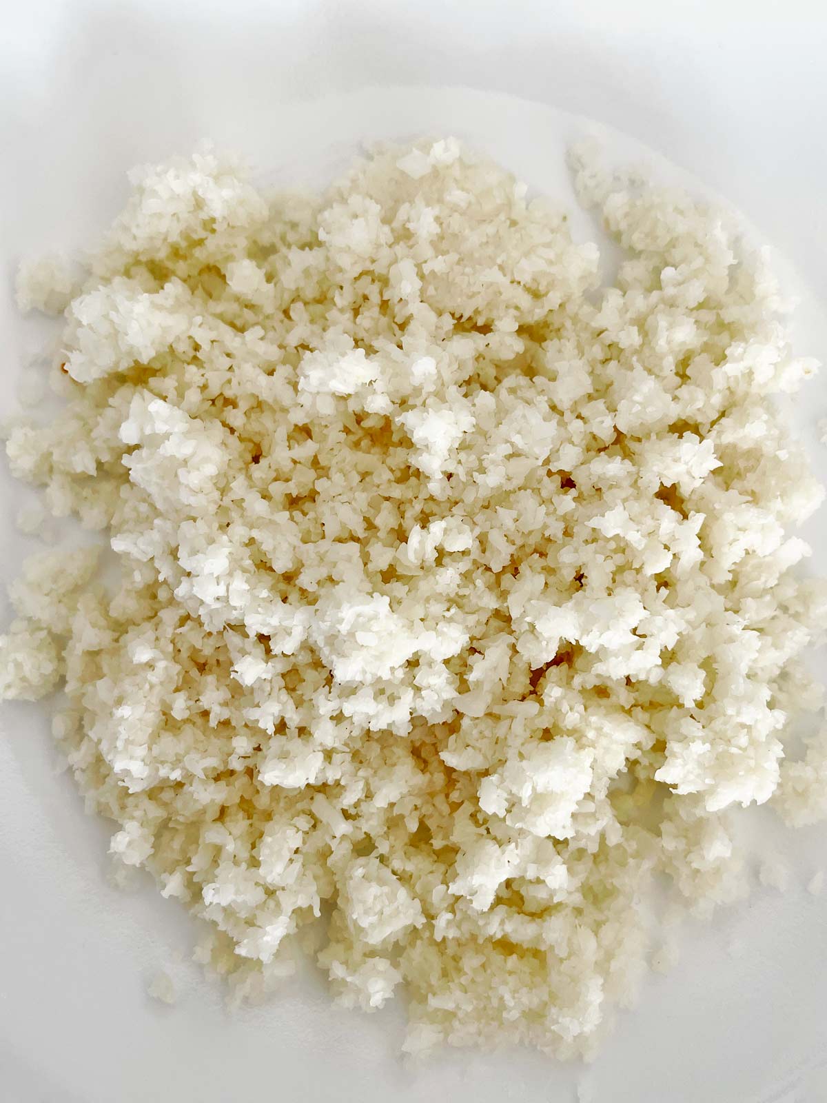 Riced cauliflower in bowl ready to microwave.