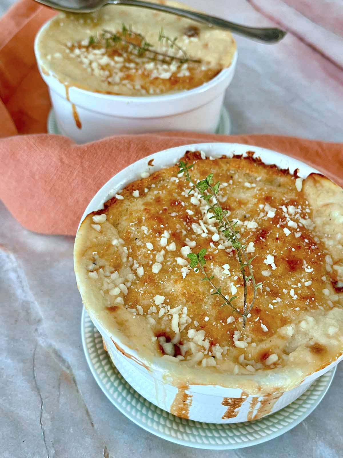Golden brown Pot pies with thyme and partisan cheese garnish.
