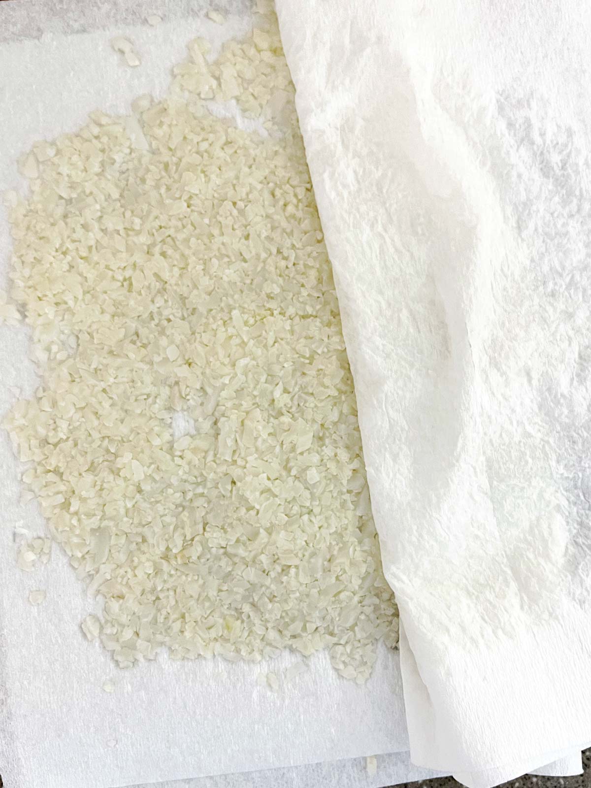 Rice being squeezed between paper towels.