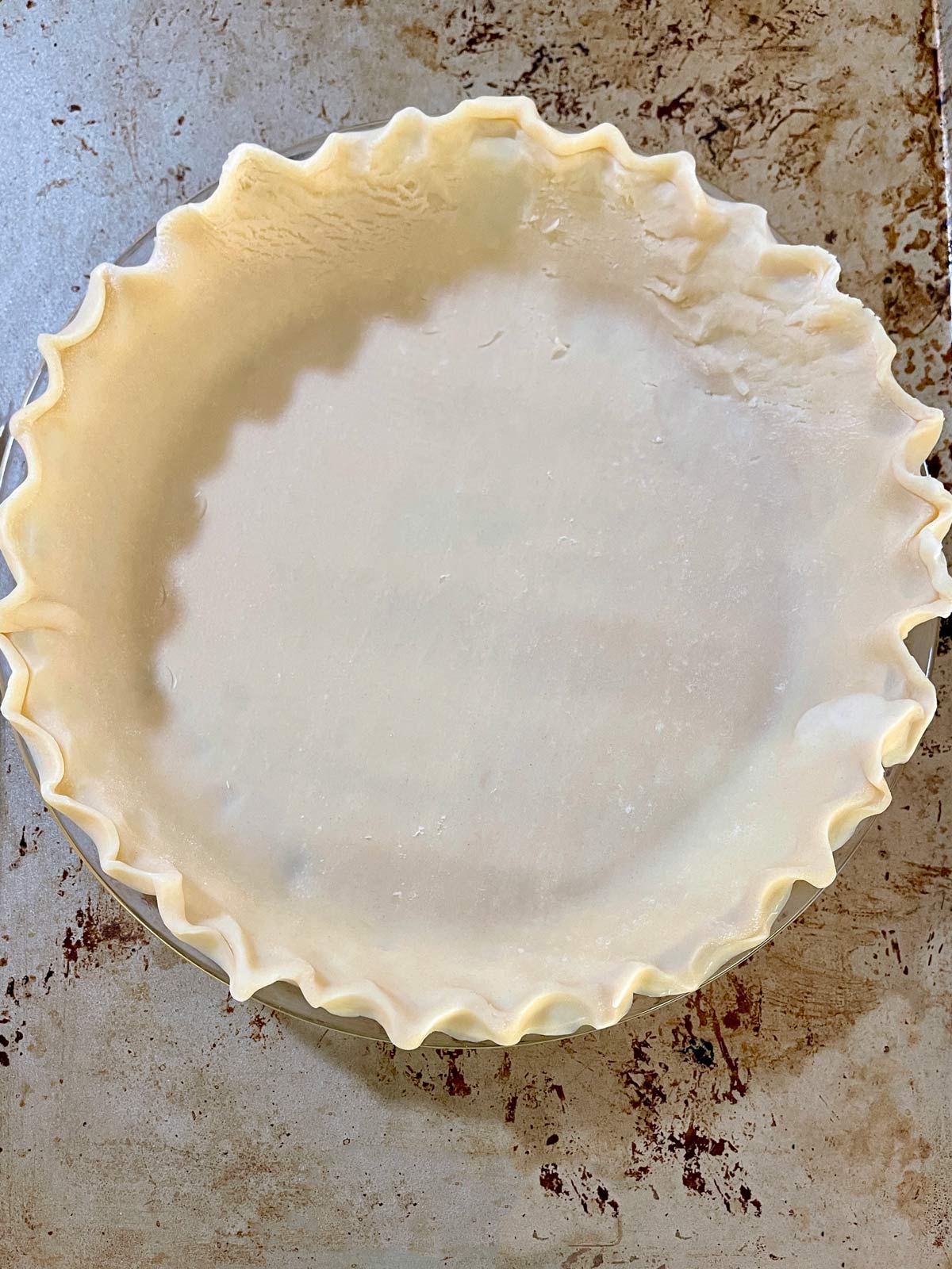 Pie crust unbaked in pie pan with fluted edsge.