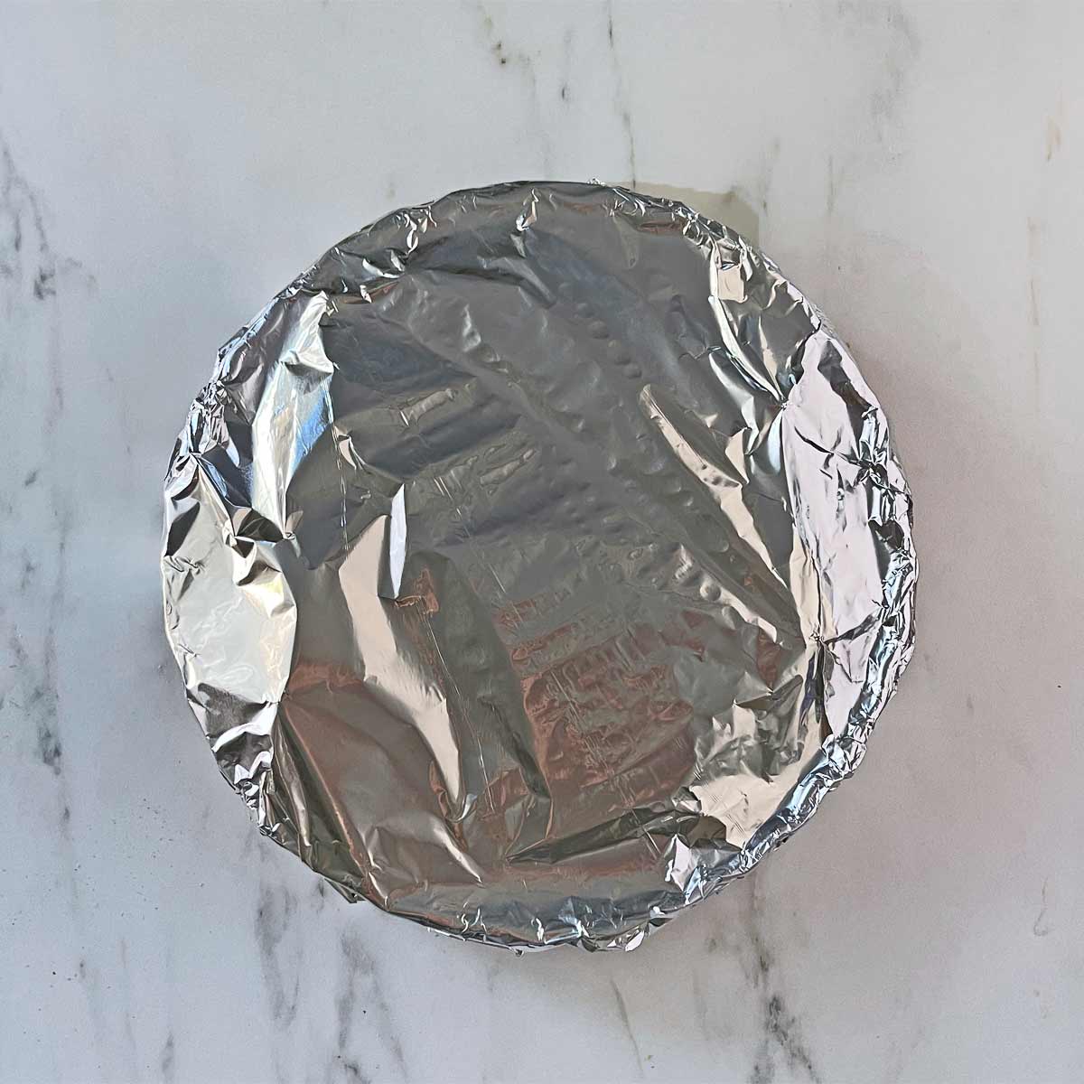 Quick Acorn Squash Recipe with Cranberries covered with foil and ready for the oven.