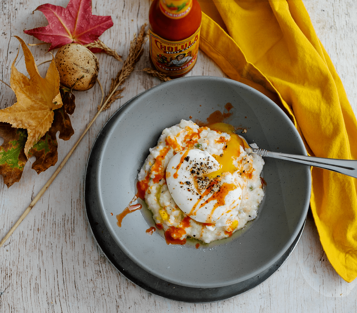 Bowl of grits with poached egg and hot sauce