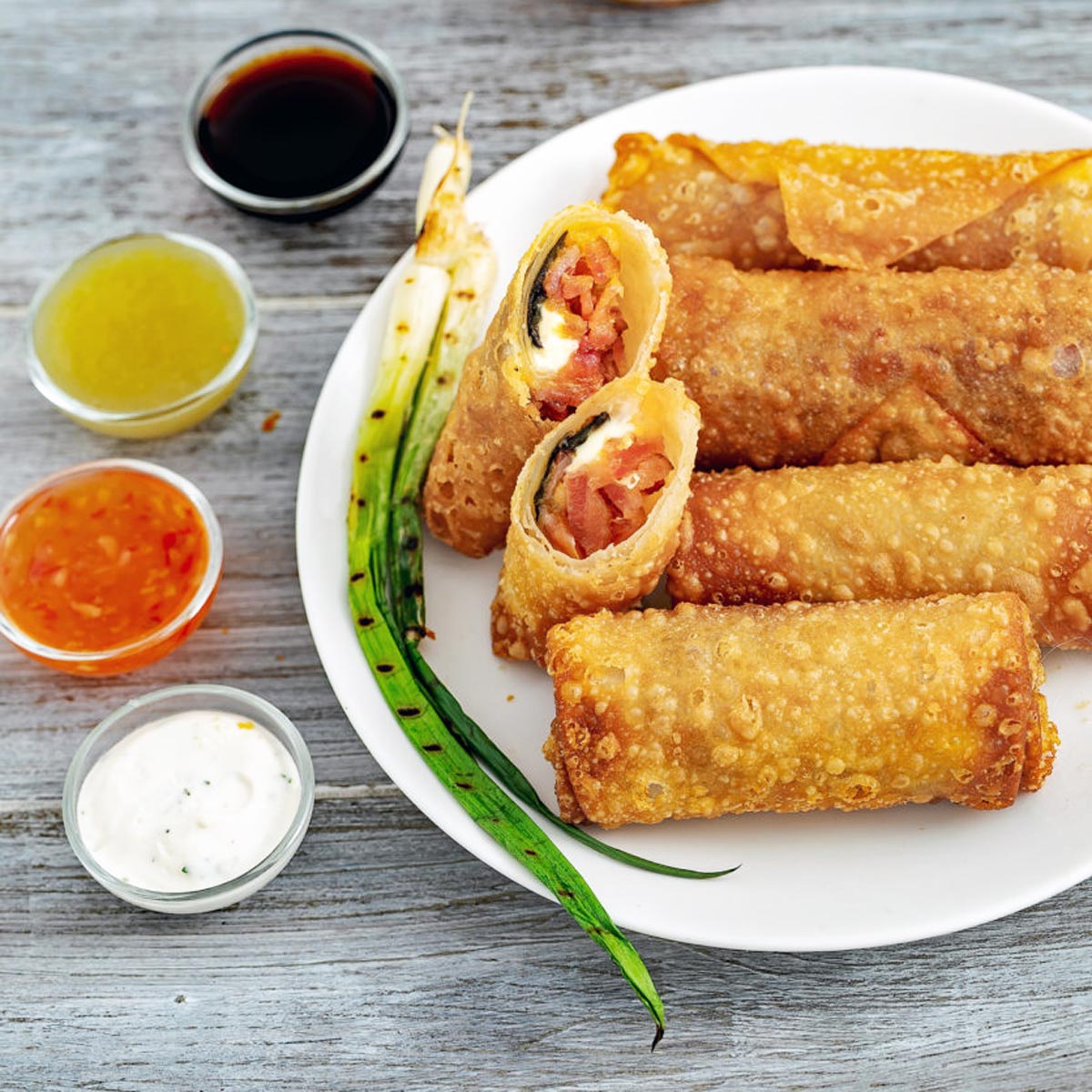 Plate of eggs rolls and sauces.
