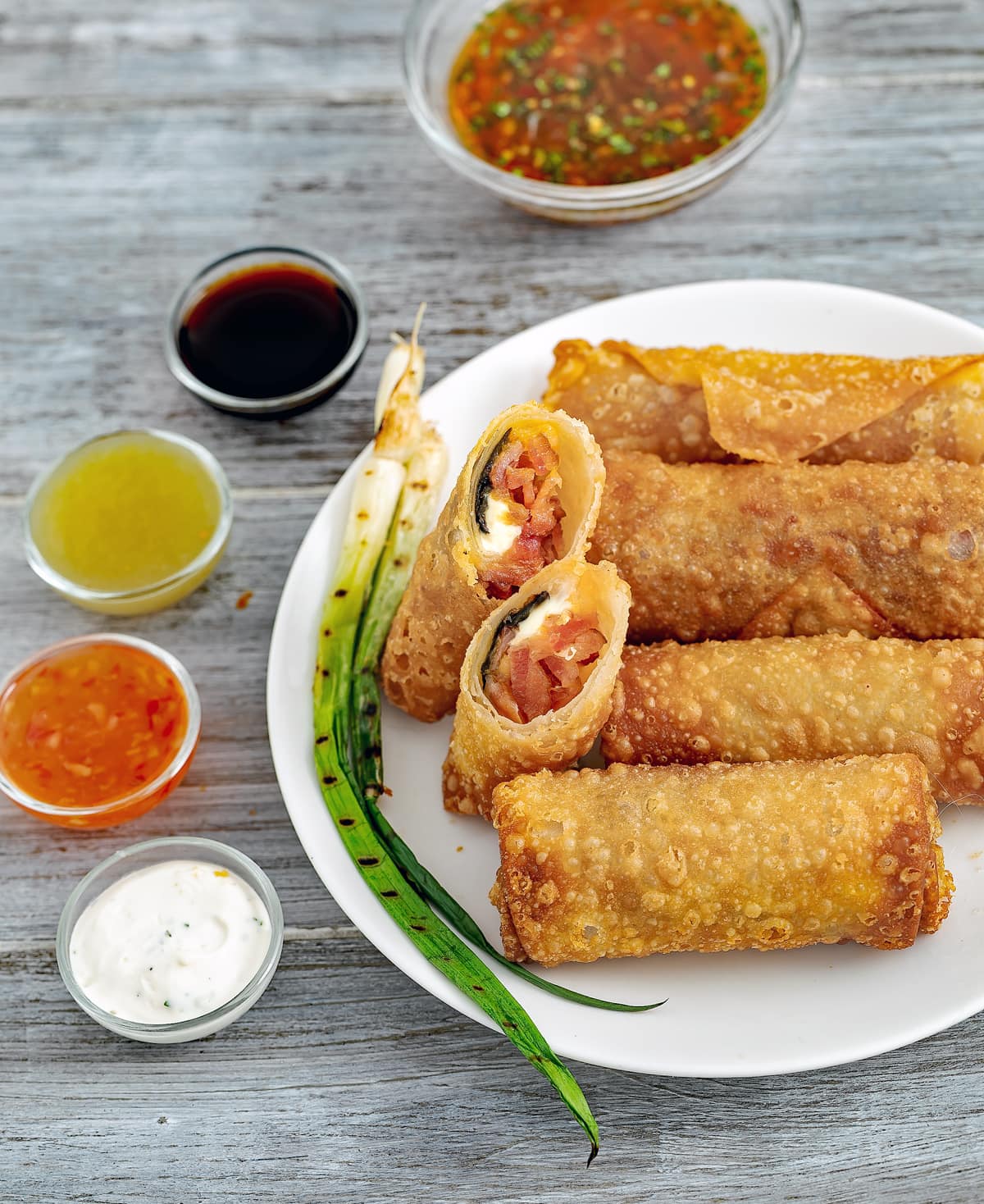 Plate of jalapeno eggrolls with sauces.