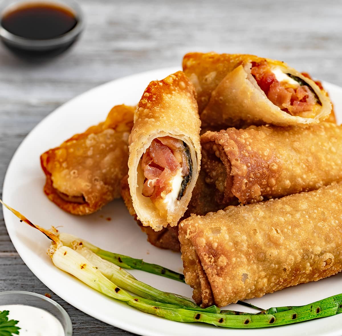 Plate of eggrolls with grill scallon.