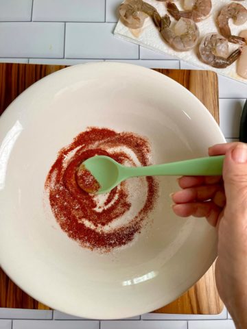 Spice rub in a bowl being mixed with a spoon.
