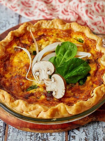 Spinach and mushroom quiche in small pie plate.