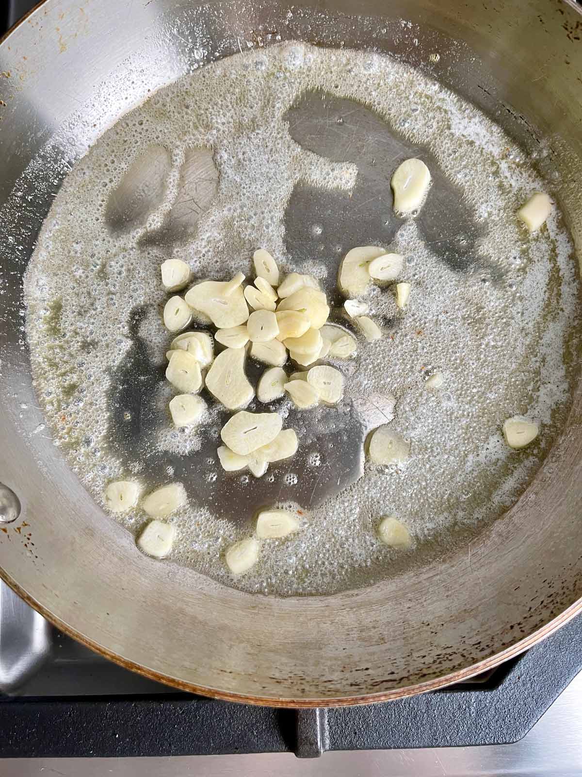 Garlic slices in pan with melted butter