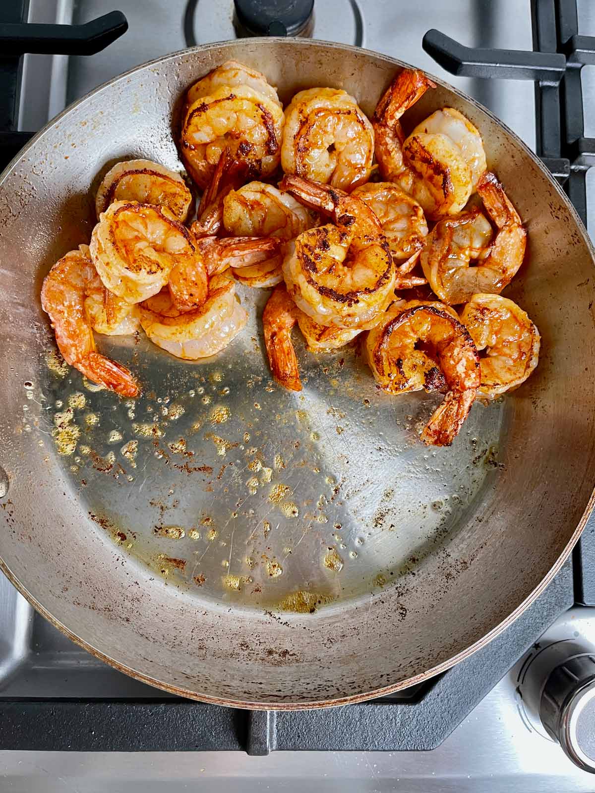 Shrimp in the pan cooked on both sides and moves to one side of the pan.