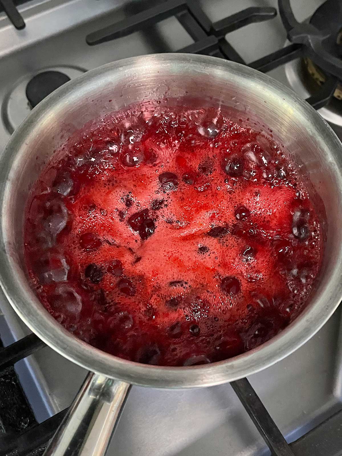 Cranberry orange sauce bubbling on stove