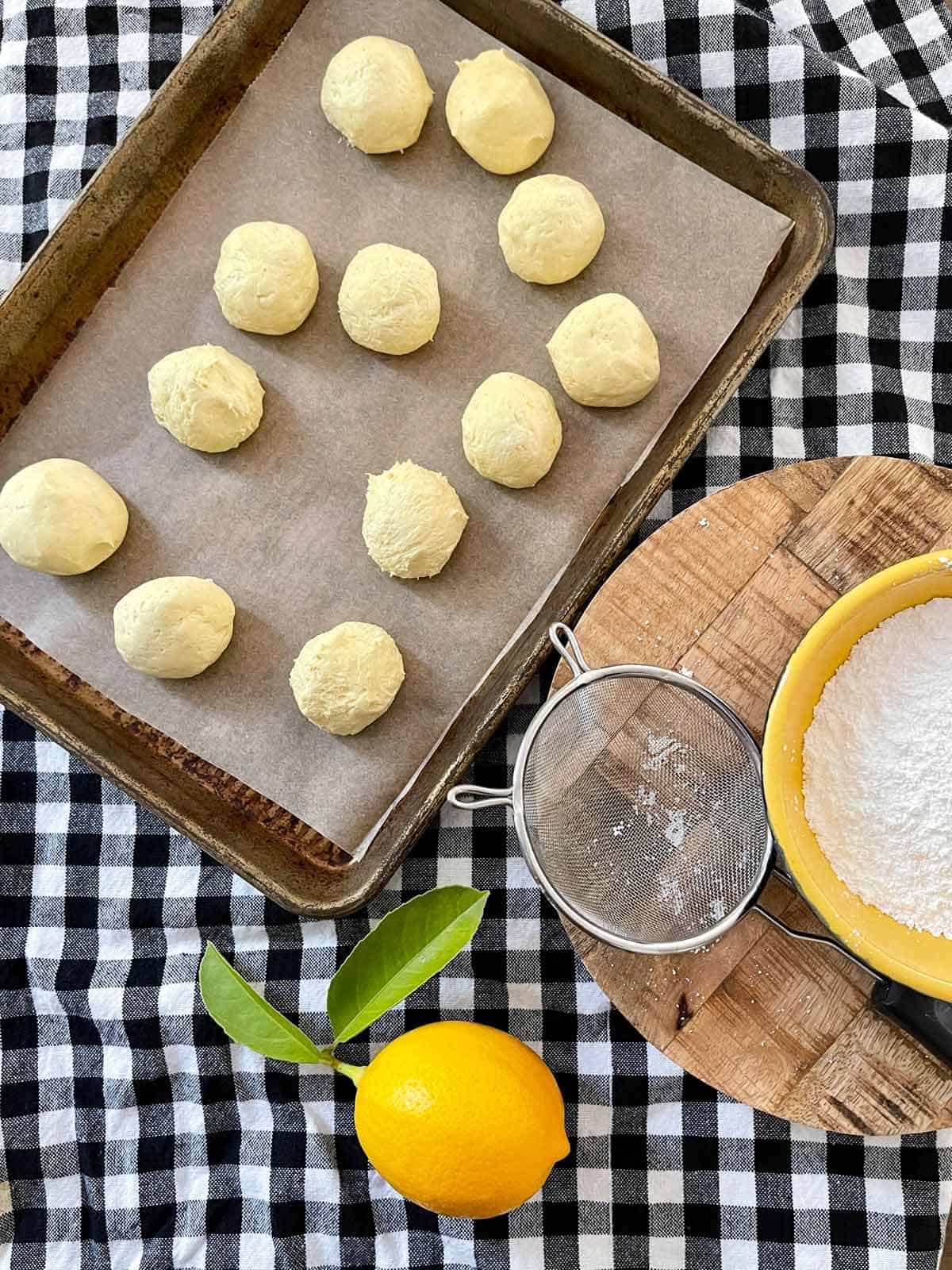 Cookie dough rolled into balls on a parchment lined baking sheet.