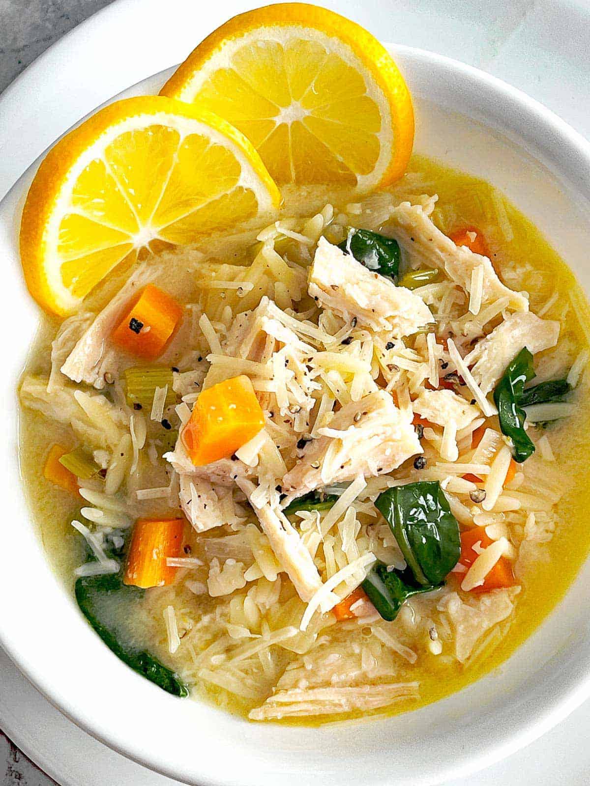 Finished soup with Parmesan cheese and lemon slices.