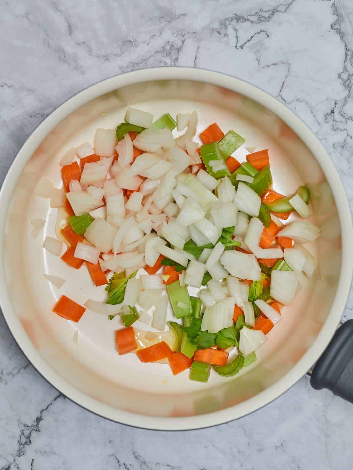 Skillet with carrots, celery, and peppers add to the oil.