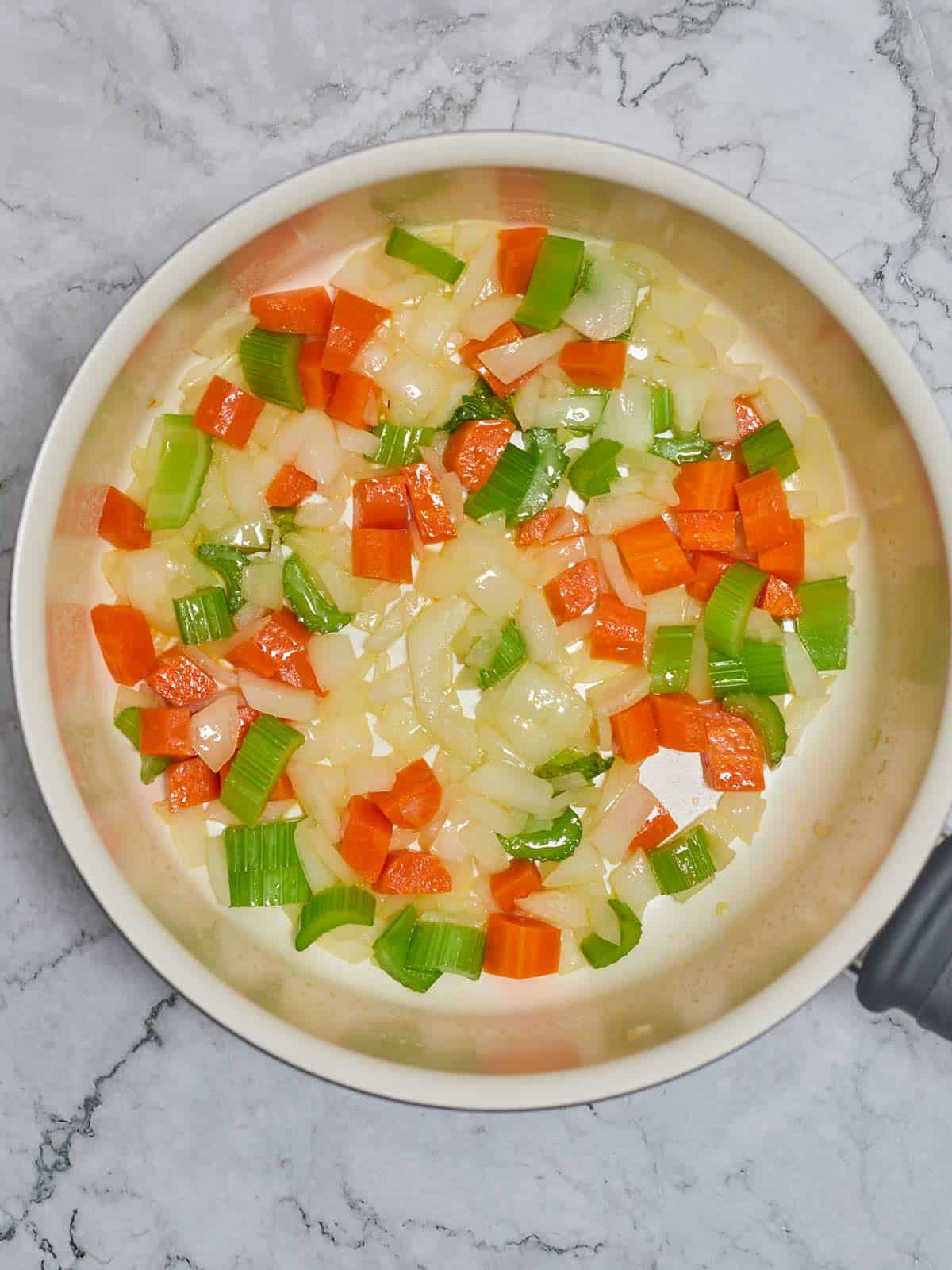 Vegetables cooking in the large skillet.