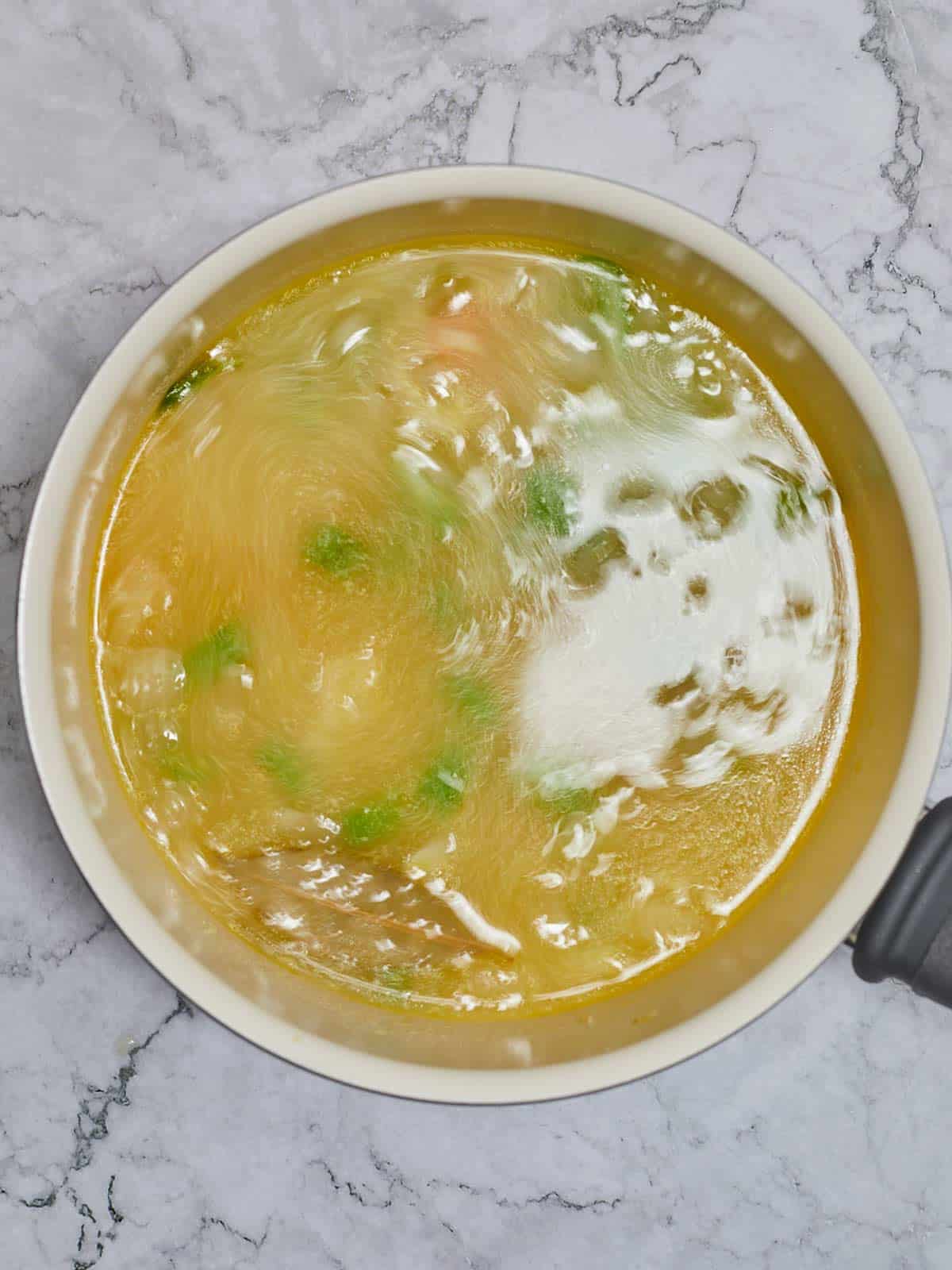 Vegetable ans chicken broth cooking in the skillet.