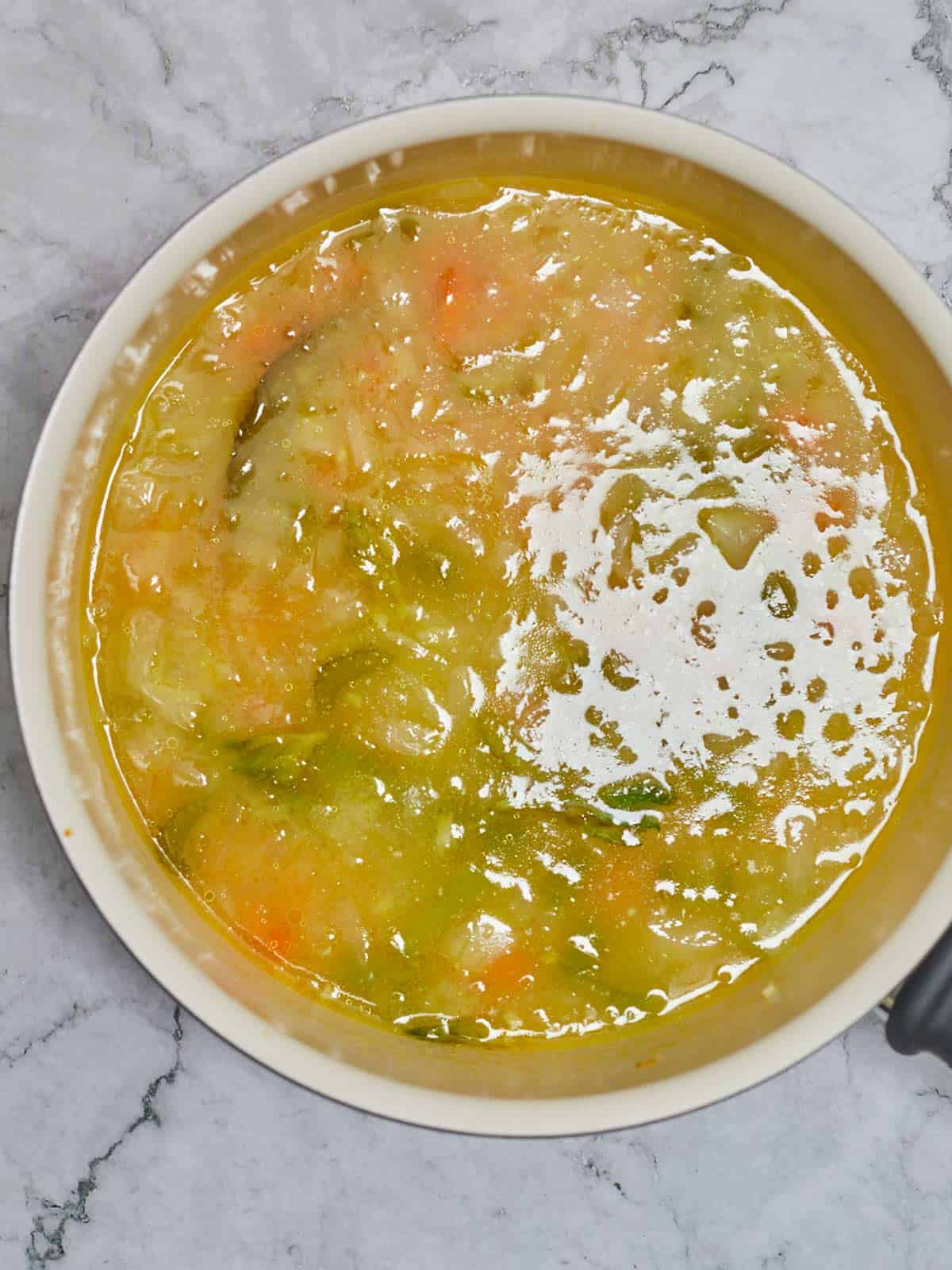 Soup is simmering on the stove to let the orzo cook.