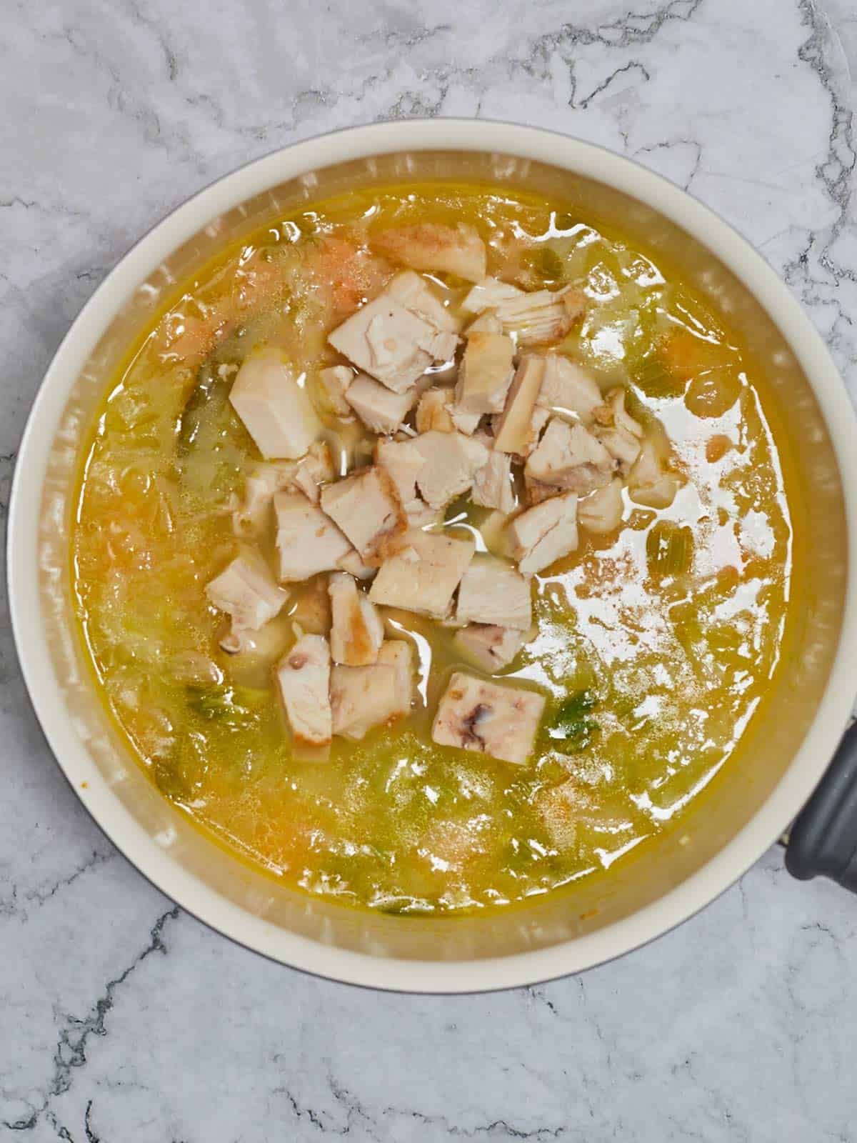 Cooked chicken has been added to the skillet with the soup.