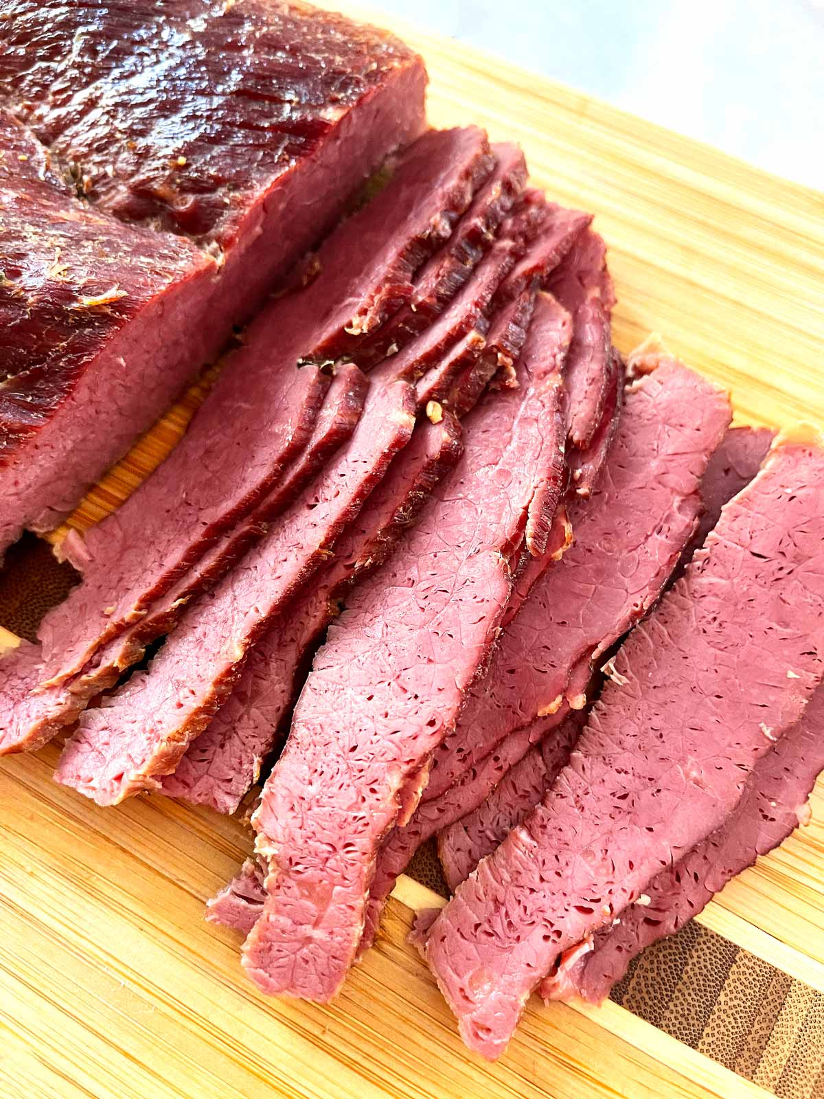 Sliced corned beef on cutting board.