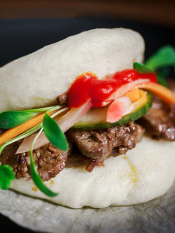 Bao bun with Asian style beef, cilantro, and hot sauce.