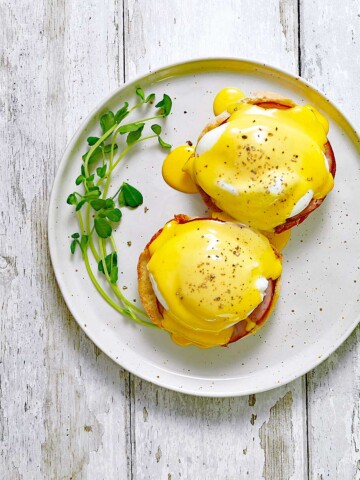 Plate with eggs Benedict with sauce.
