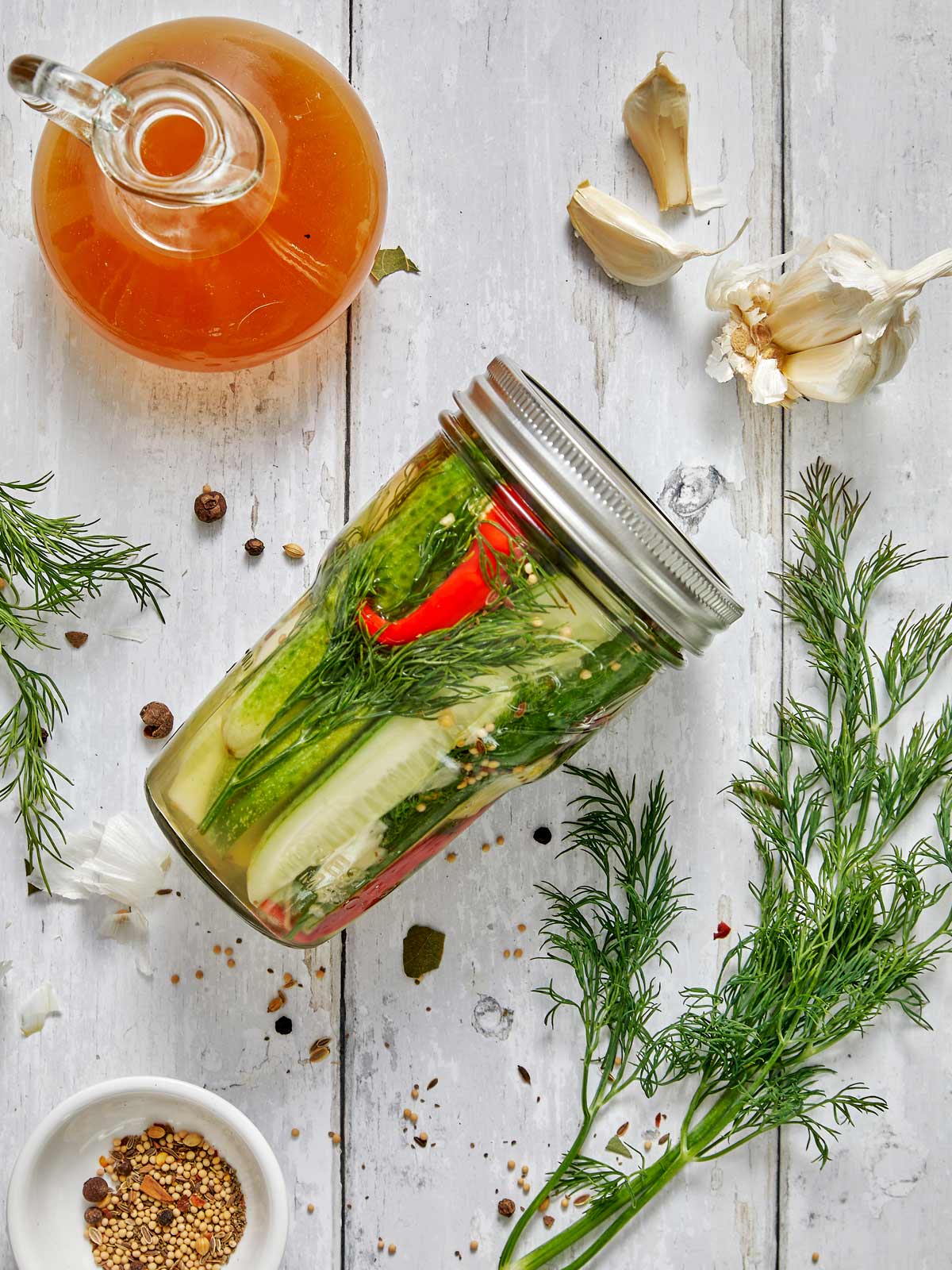 Glass jar of pickles lying on its side.