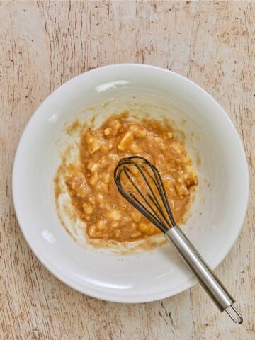 Banana muffin 
ingredients mixed in a bowl with a whisk.