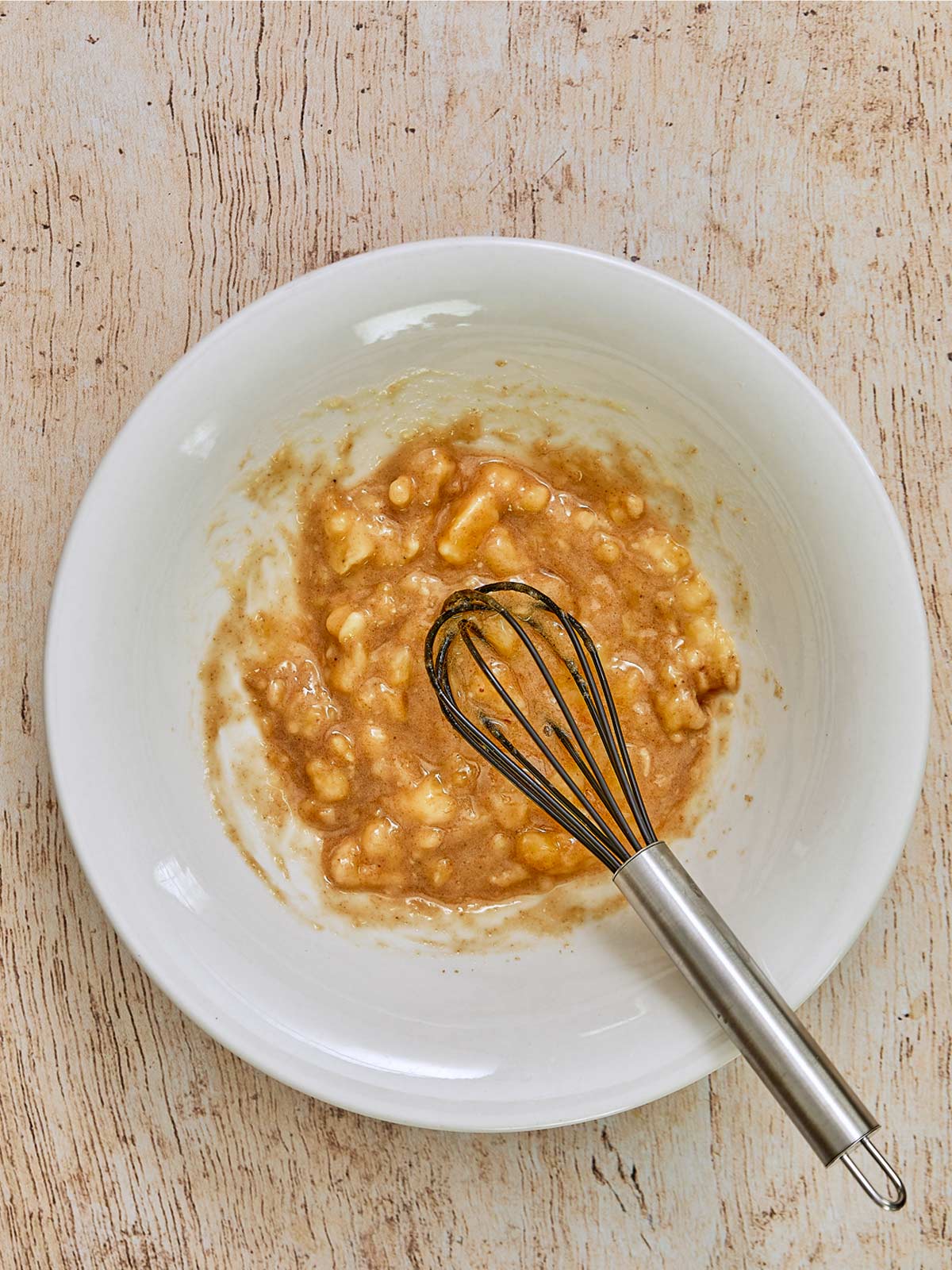 Banana muffin
ingredients mixed in a bowl with a whisk.