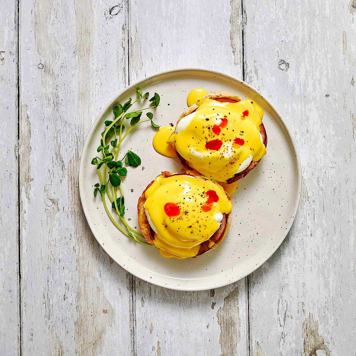 Eggs Benedict with hot sauce on top. Ready to eat.