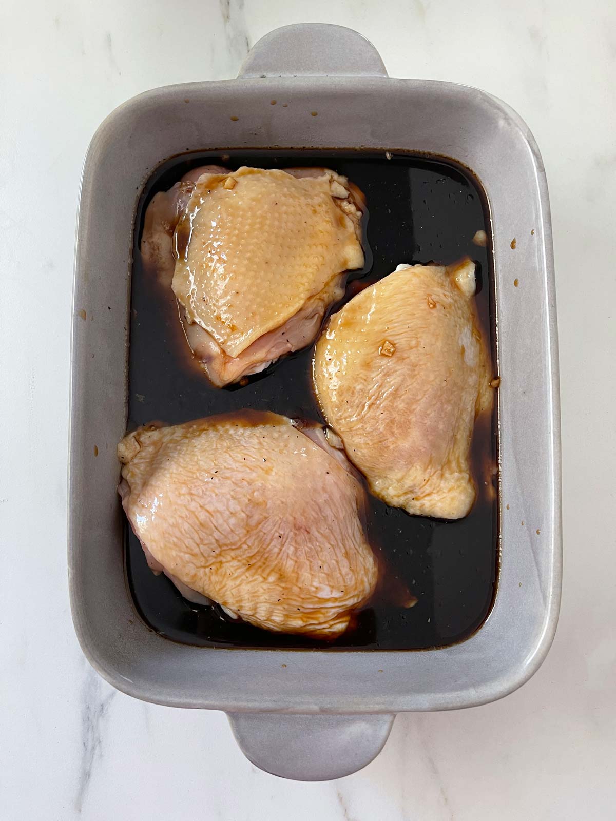 Cooking liquid poured over the chicken thighs.