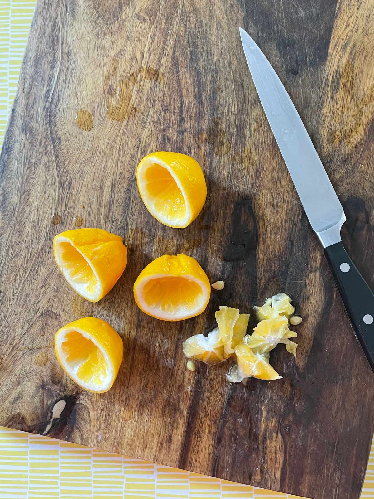 Image of lemon peels with the insides cut out and sharp knife.