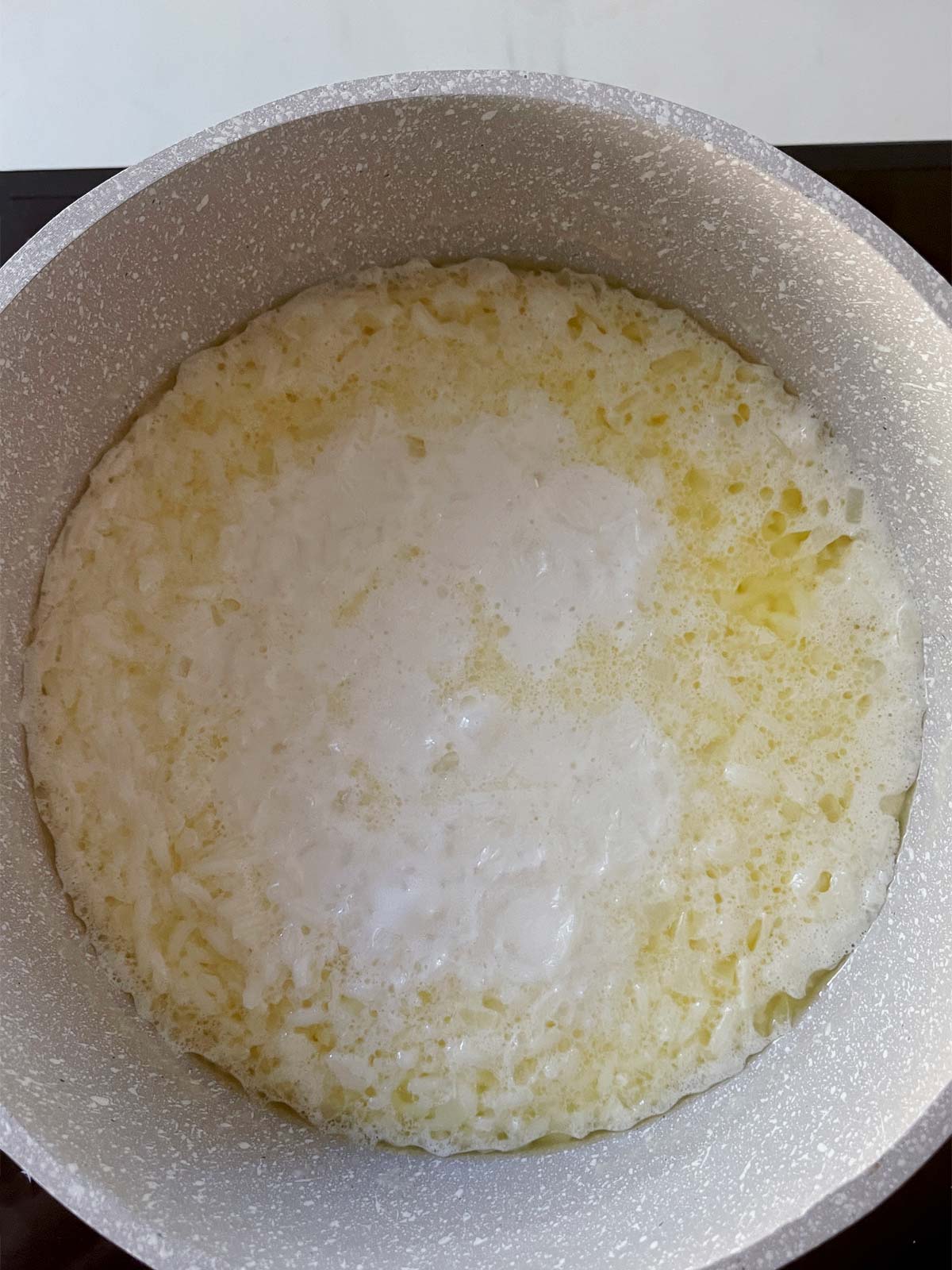 Pot with rice cooking with butter.