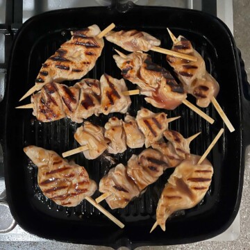 Chicken cooked on one side with grill marks.