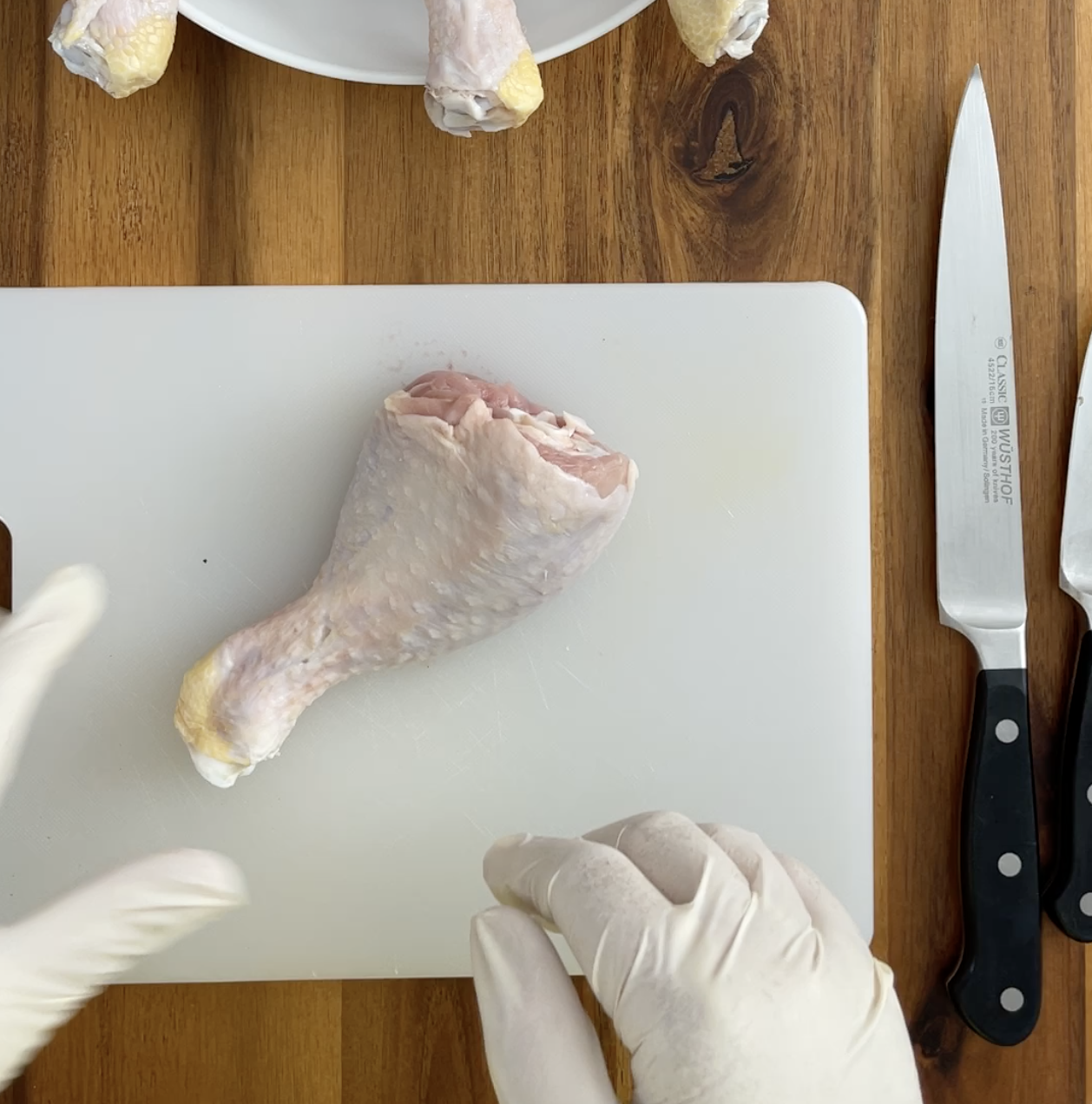 Raw chicken leg on cutting board.