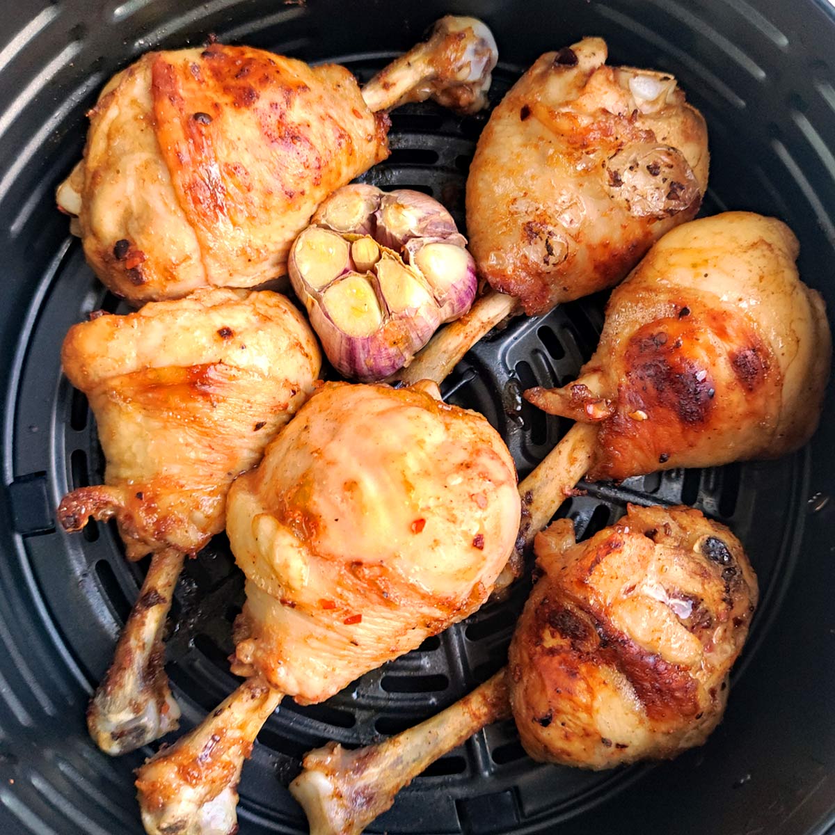 Chicken wings in air fryer, cooked on one side.