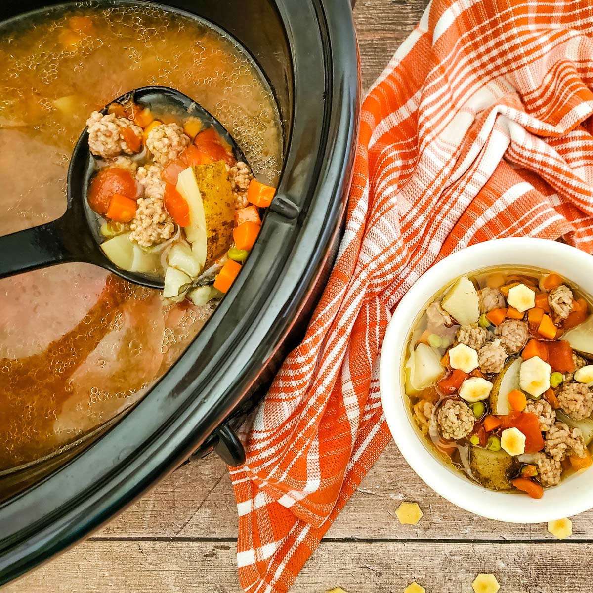 Cooked soup being ladled out of crockpot and into a bowl.