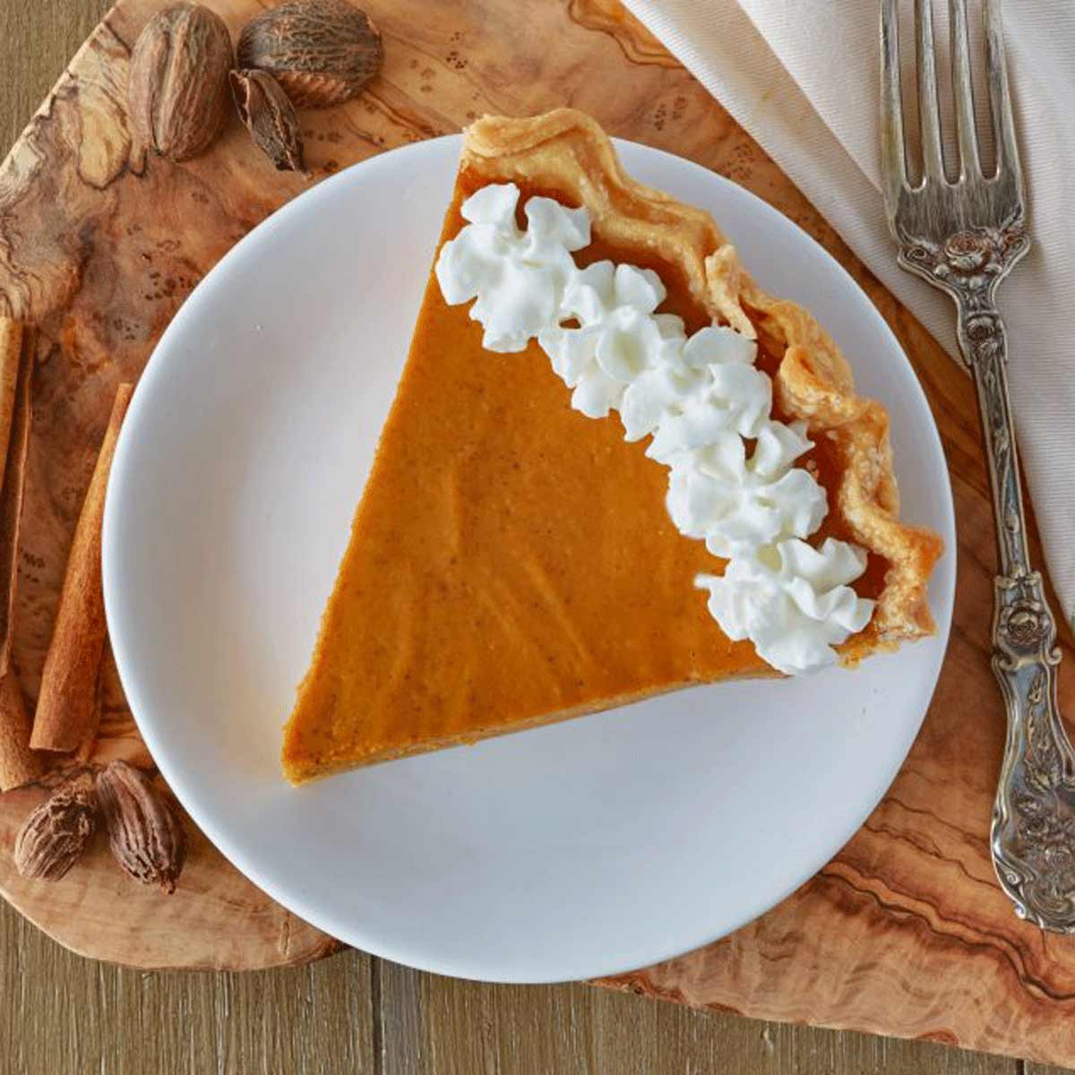 Plate with pumpkin pie with whipped cream.