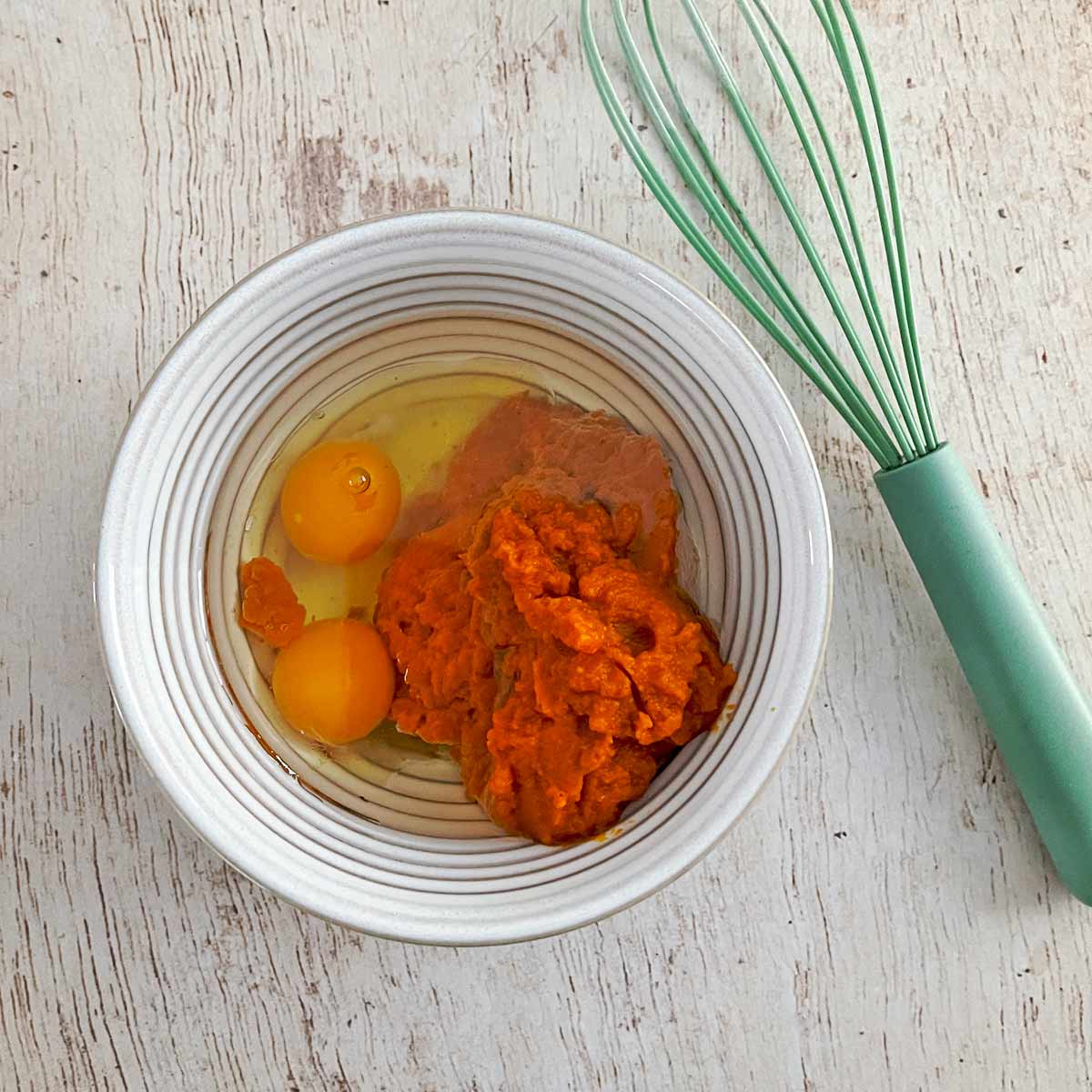 Mixing bowl with pumpkin puree, eggs, and oil.