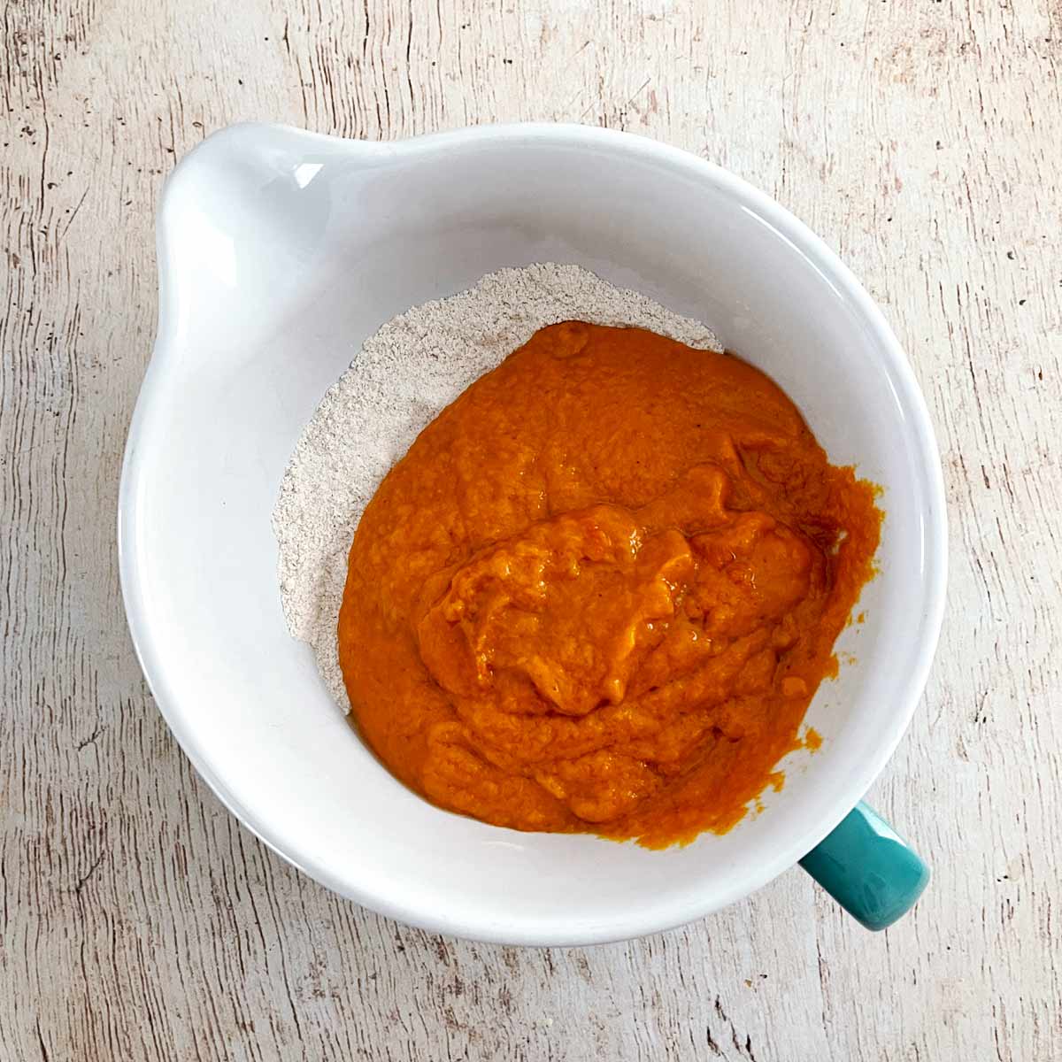 Bowl with dry ingredients and pumpkin puree mixture.